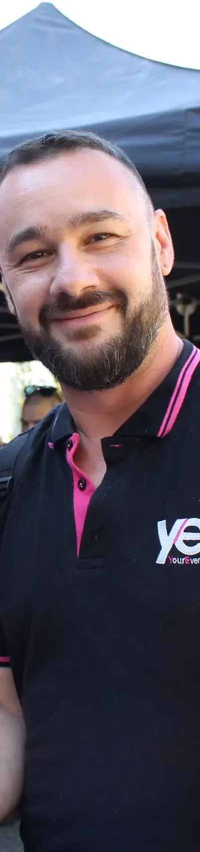 Coordinatore YES con la polo aziendale sorride durante il briefing